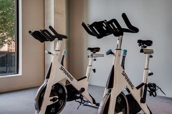 A group of white exercise bikes in a room